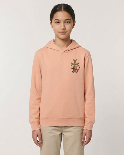 A young girl wearing a peach-colored hoodie with a floral embroidered design on the front.