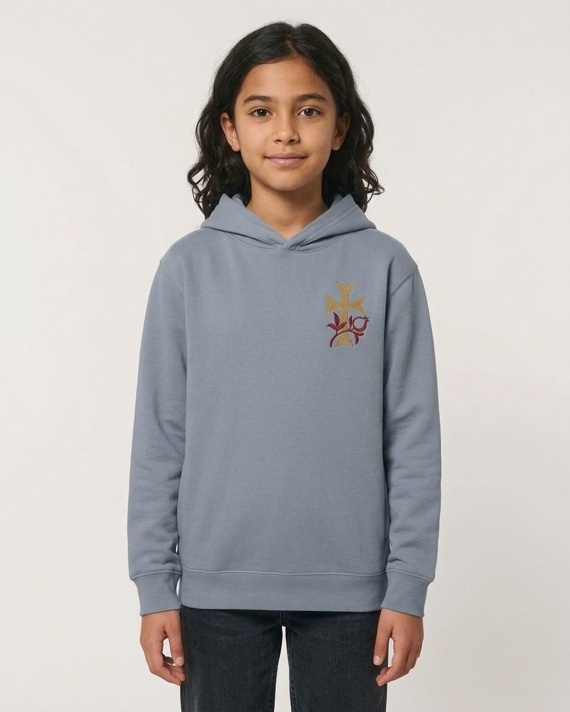 A young girl wearing a gray hoodie with a floral embroidered design on the front.
