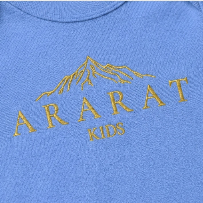 Blue baby onesie with gold 'Ararat Kids' text and mountain design on a beige background