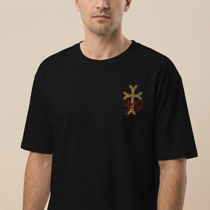 Man wearing a black t-shirt with a gold and red emblem on a beige background